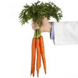 Doctor's Hand Holding Bunch of Carrots